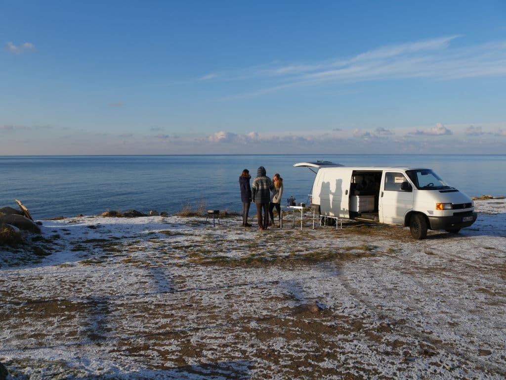 Campervan mit Vorzelt direkt an der Ostsee bei Sonnenaufgang