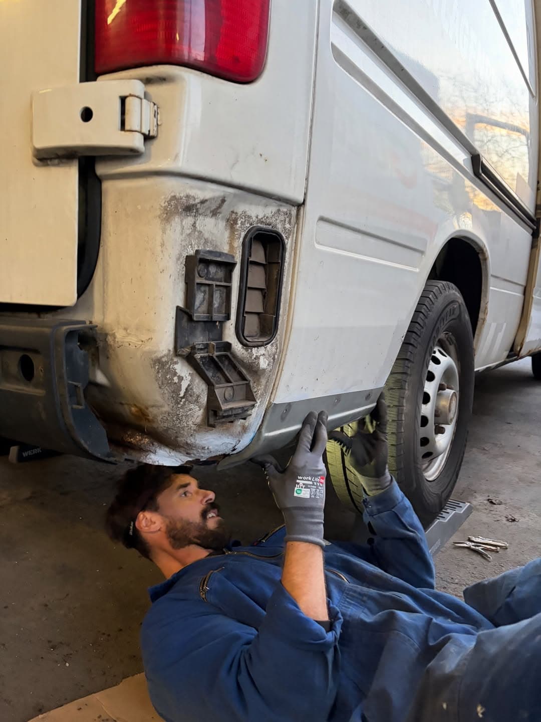Olli bei Wartungsarbeiten unter dem Van in der Werkstatt